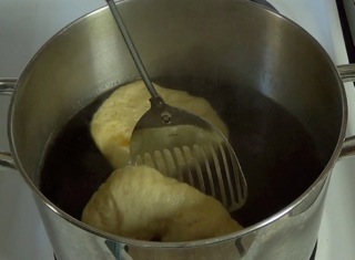 flipping the bagels in the boiling water