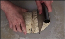 cutting the dough in half with a bench knife