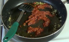 adding tomato paste and turmeric