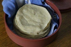finished tortillas stacked in the warmer.