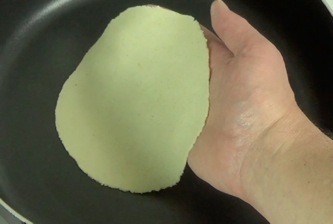 putting the tortilla in the low temperature frying pan