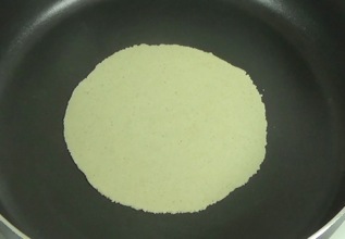 tortilla cooking on the first side