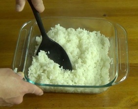 Gently folding the rice with a plastic spatula