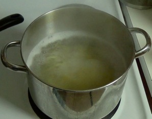 mixing pasta into boiling water