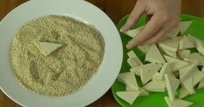 pressing the tofu into the sesame seeds